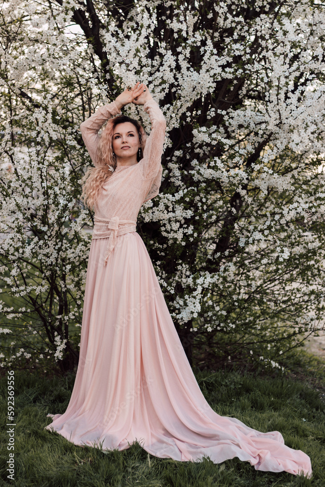 A beautiful woman in a dress near a cherry blossom. Spring Day A beautiful woman in a dress near a cherry blossom. Spring Day