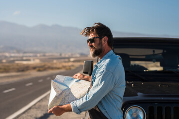 Car travel tourism concept, One tourist outside the vehicle with paper guide map find roads to arrive at destination. Adventure vacation explorer lifestyle people. Black off road. Straight long road