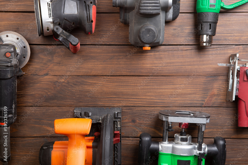 Set of electric tools on the wooden table. Various power tools for renovation and construction Set of electric tools on the wooden table. Various power tools for renovation and construction