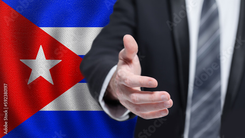 Cuba politics, cooperation and travel concept. Hand on Cuban flag background.
