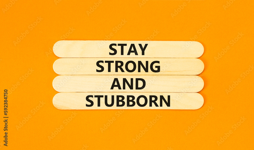 Stay strong and stubborn symbol. Concept words Stay strong and stubborn on wooden stick. Beautiful orange table orange background. Motivational business stay strong and stubborn concept. Copy space. Stay strong and stubborn symbol. Concept words Stay strong and stubborn on wooden stick. Beautiful orange table orange background. Motivational business stay strong and stubborn concept. Copy space.