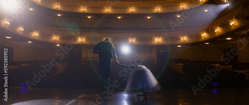 Obraz na plátně Ballet dancers bow at the end of choreography rehearsal on classic theater stage illuminated by spotlight