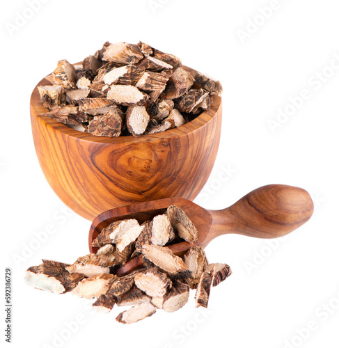 Calamus root in wooden bowl and spoon, isolated on white background. Sweet flag, sway or muskrat root. Dry root of Acorus calamus. photo