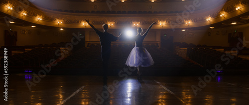 Pair of ballet dancers practice choreography moves on theater stage and prepare for theatrical dance performance together. Ballerina with partner on show rehearsal. Concept of classical ballet art.