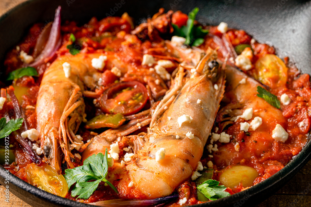 Prawns in a cast iron skillet with tomatoes and feta cheese.