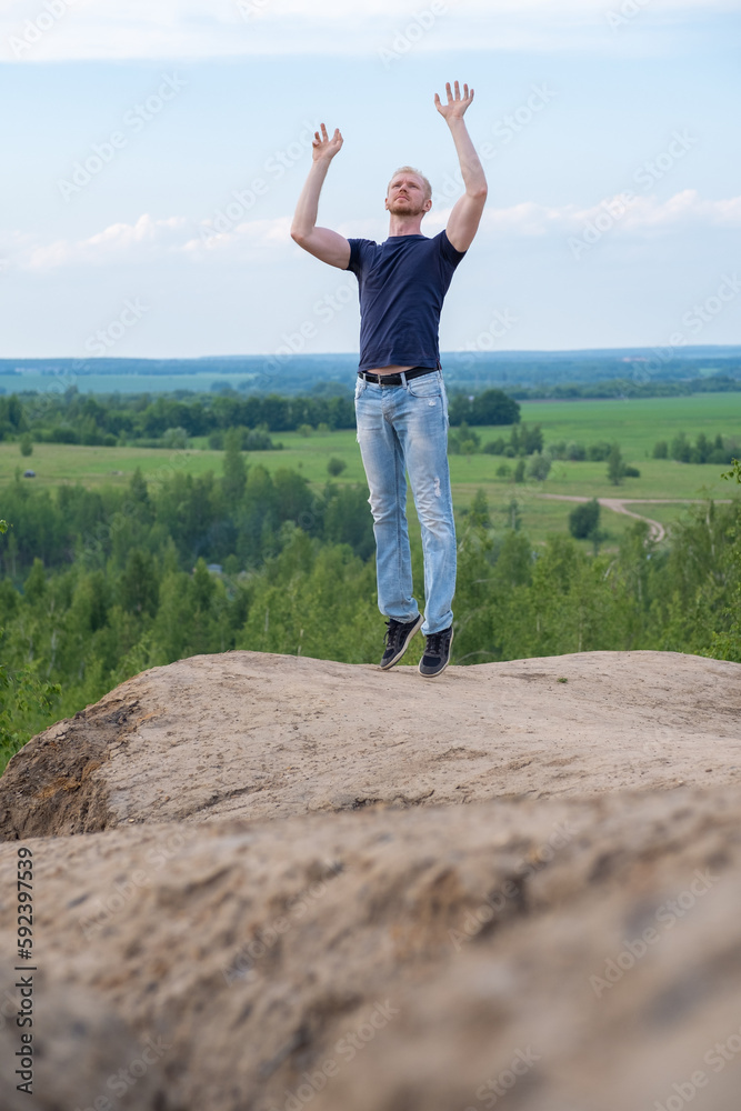 Naklejka premium A man surrounded by mountains and forests. A man in a jump