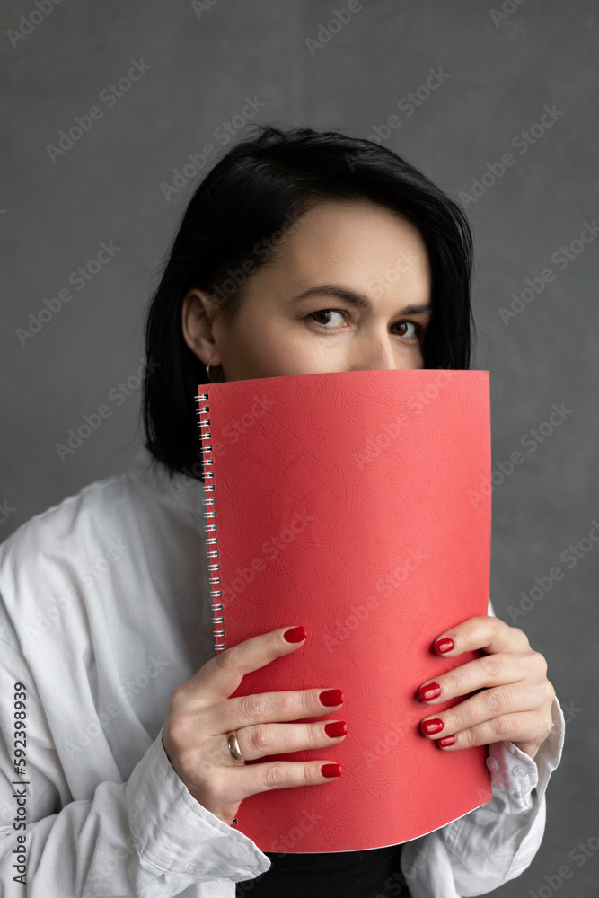 Girl in a white shirt with a short haircut, writer holding a notebook Girl in a white shirt with a short haircut, writer holding a notebook
