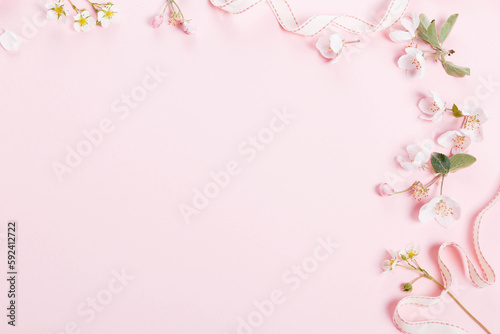 Floral pattern with wildflowers, green leaves, branch on pink background. Flat lay