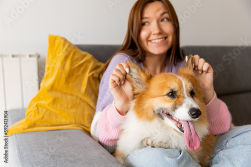 cute young woman taking care and petting her adorable corgi dog . Man's friend and Lifestyle