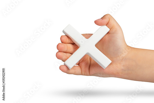 White multiplication symbol or cross in hand. The concept of prohibition or removal of something. Mathematical white multiplication symbol in hand on a white isolated background