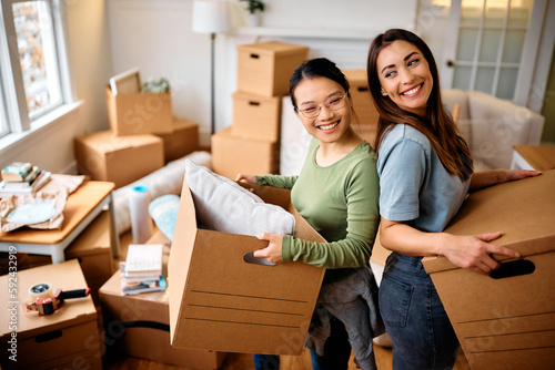 Happy female friends moving into new apartment.