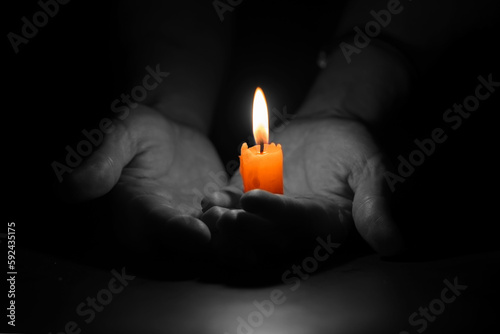 Bright Burning Candle in the Human Hands. Remembrance and Memorial Day Symbol.