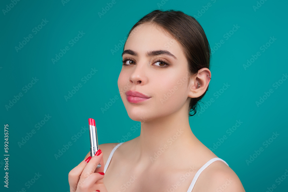 Obraz premium Lipstick, beauty and cosmetics. Beautiful woman applying lipstick on lips. Mockup for cosmetics, makeup. Lips color product, balm cosmetic on studio background.