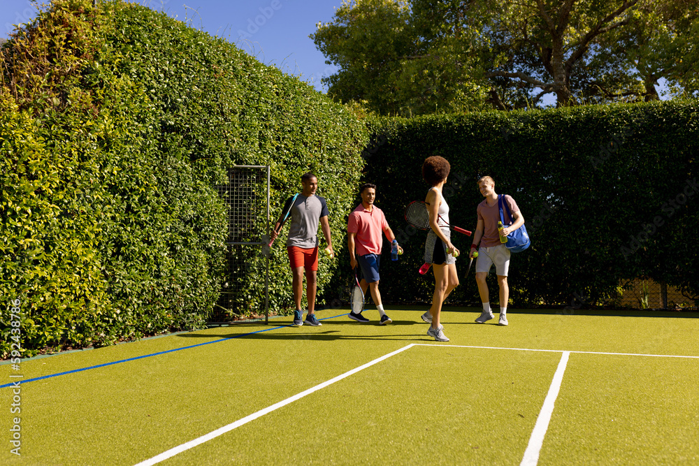 Obraz premium Happy diverse group of friends arriving together at tennis court