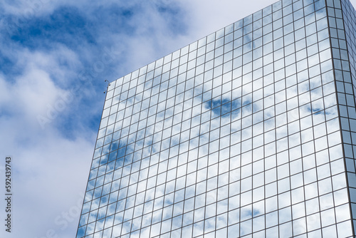 Clouds reflect off mirrored glass skyscraper