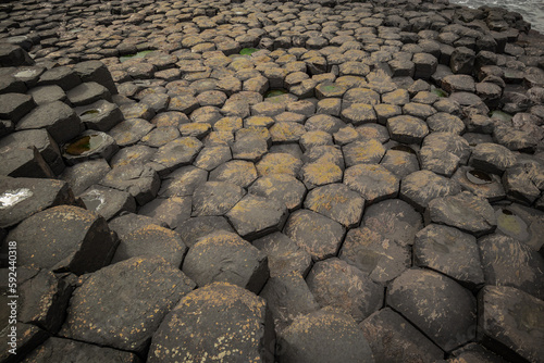 Detail of hexagonal stones or pillars at Giants causeway in northern ireland, majestic basalt pillars at the beach on a cloudy day. Wide view of area..
