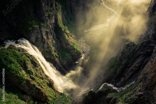 Amazing sunbeams passing through the mist created by the Voringfossen waterfalls, Norway