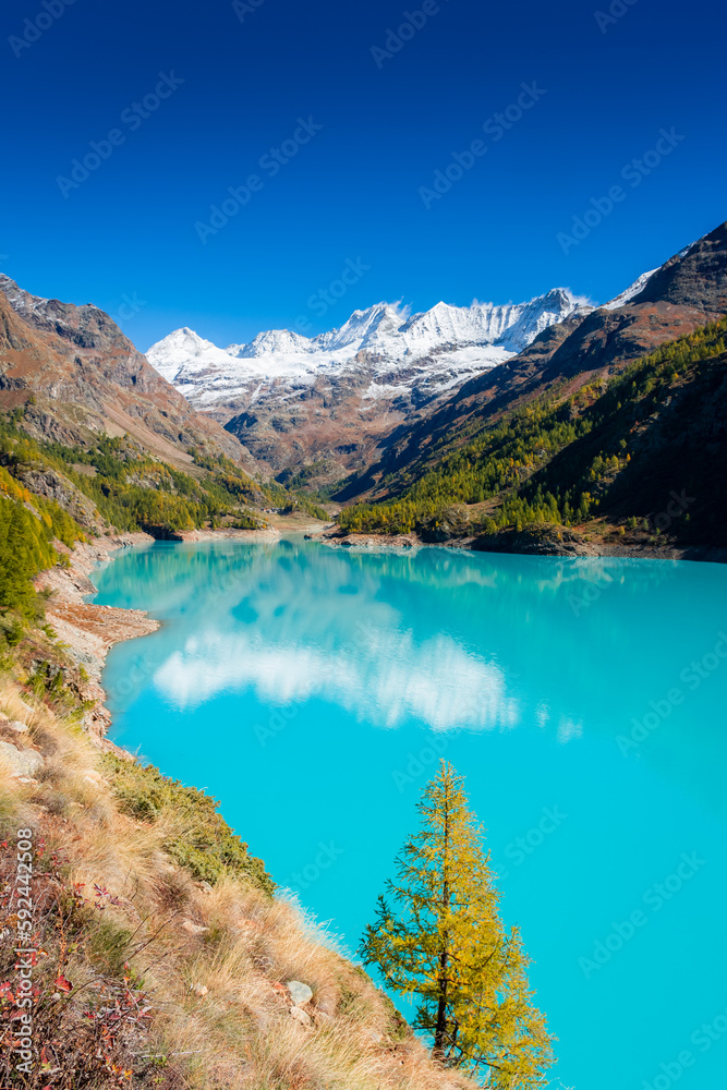 Fototapeta premium Autumnal landscape of the Lake Place Moulin, an artificial glacial lake with turquoise water in the italian Alps, on the border with Switzerland