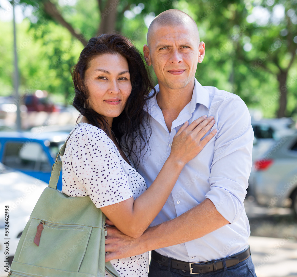 Fototapeta premium Woman and man hugging each other in parking lot