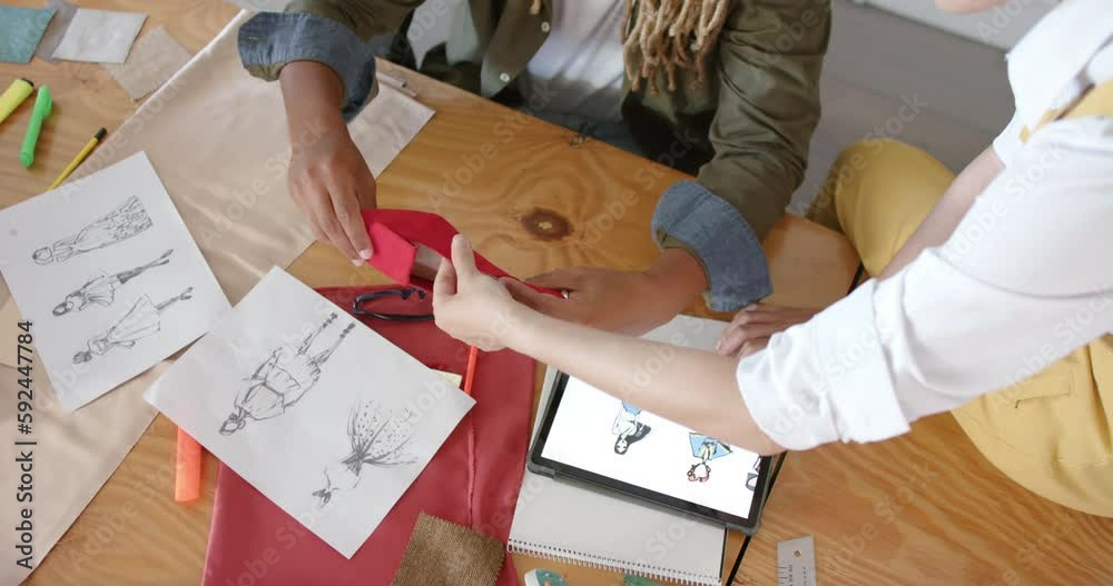 Busy diverse designers discussing shoe in fashion design studio, in slow motion Busy diverse designers discussing shoe in fashion design studio, in slow motion