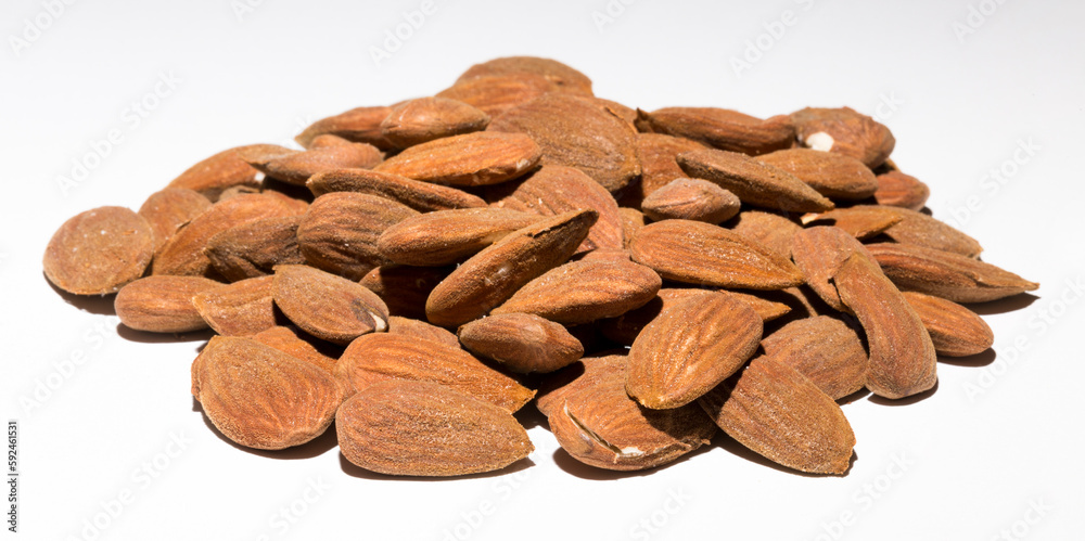 Shelled almonds (Prunus dulcis). A lot of peeled almonds on a white field. Shelled almonds (Prunus dulcis). A lot of peeled almonds on a white field.