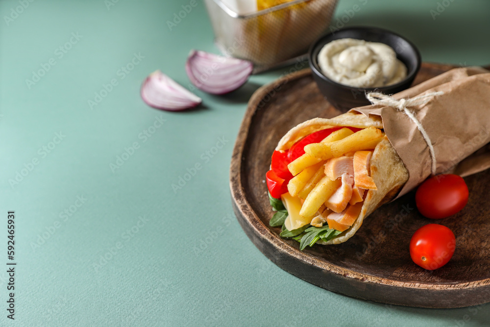 Delicious pita wrap with chicken, french fries and pepper on light blue background, space for text Delicious pita wrap with chicken, french fries and pepper on light blue background, space for text