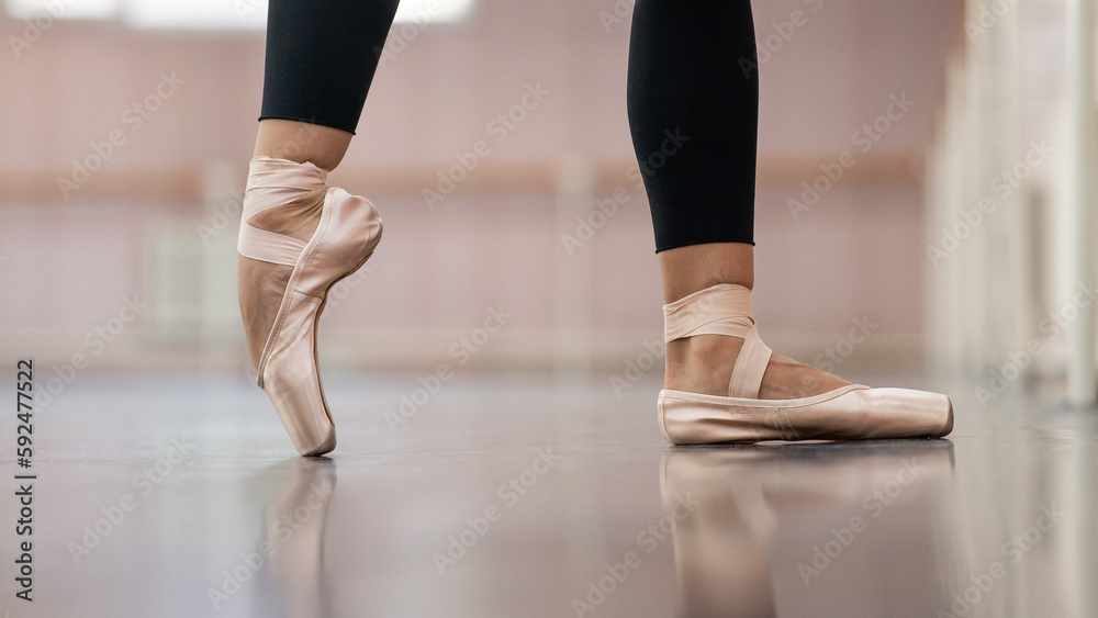 Close-up but ballerinas in pointe shoes in a dance class. The woman stands on one toe. Close-up but ballerinas in pointe shoes in a dance class. The woman stands on one toe.