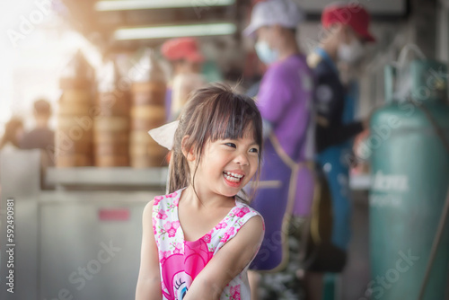 Asian little girl smiling happily at dim sum shop 