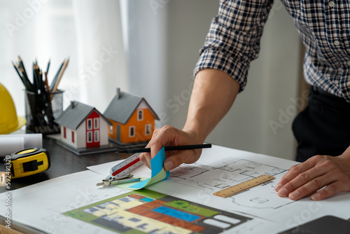 Fotografi Engineers, architects, contractors look and choose color schemes to lay out proper house plans on blueprints at desk with ruler in office at construction site to design housing plan