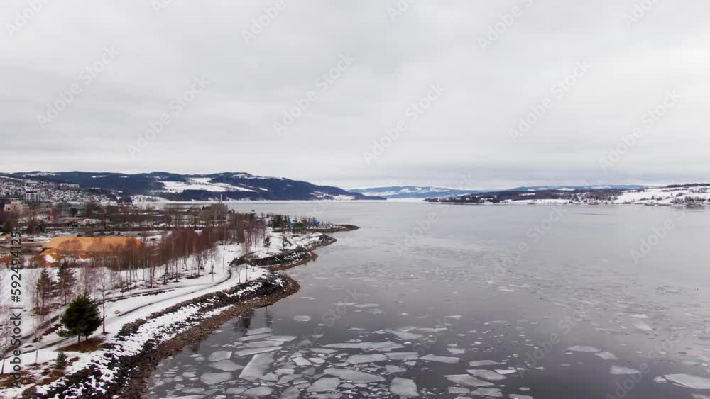 European wintery landscape with freezing lake. Dolly right drone shot. European wintery landscape with freezing lake. Dolly right drone shot.