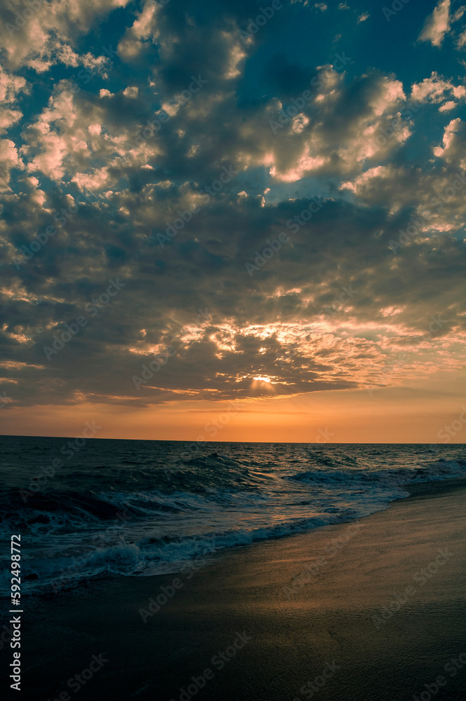 Fototapeta premium Sunset on black sand beach in Guatemala, tropical sunset full of color and waves.