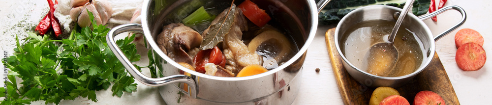 Pot of soup with beef and fresh vegetables on a white background. Pot of soup with beef and fresh vegetables on a white background.