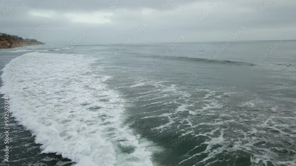 View from a drone flying back over the coast on a cloudy day View from a drone flying back over the coast on a cloudy day