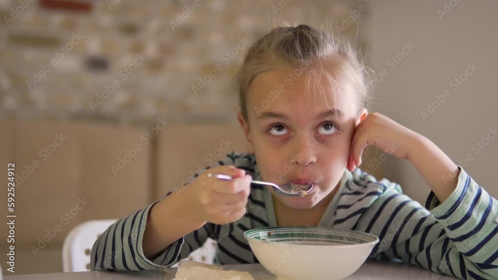 Little girl is having milk healthy breakfast while watching TV Little girl is having milk healthy breakfast while watching TV