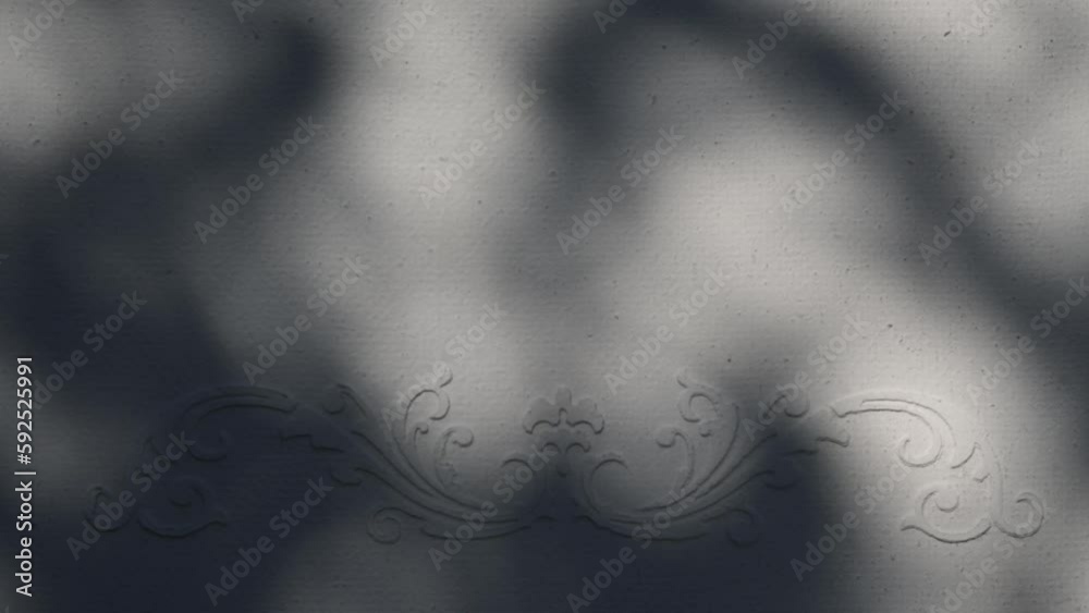 Closeup branch tree leaves silhouette shadow motion on wall with floral ornament