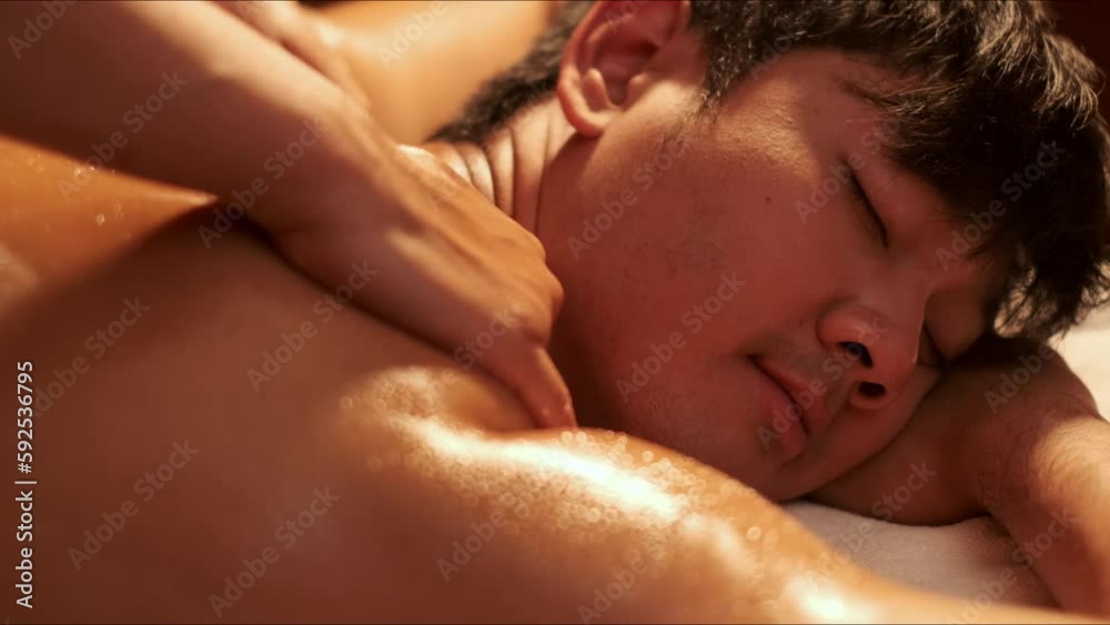 Hand of masseuse doing massage back with aromatherapy oil on back of a man customer in spa salon. Hand of masseuse doing massage back with aromatherapy oil on back of a man customer in spa salon.