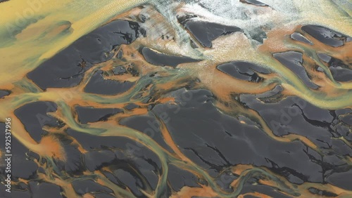 Aerial view of a colourful braided glacial river on black sand beach on the south coast of Iceland photo