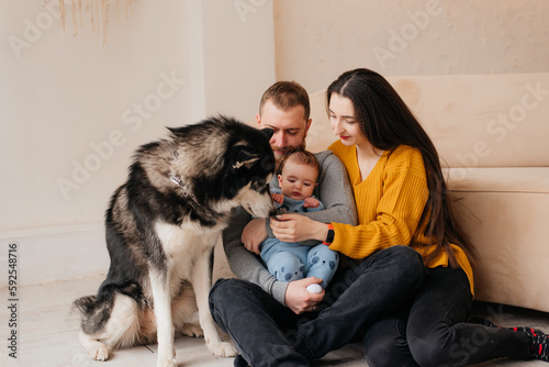 Husband and wife and their son and a pet at home.