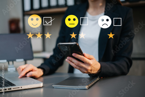 Customer service evaluation concept. Businesswoman pressing face smile emoticon show on virtual screen at tablet and smartphone