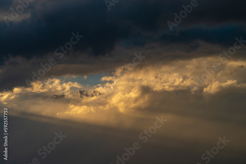 Beautiful dramatic sky with sunbeams through the clouds at sunset © vigenmnoyan