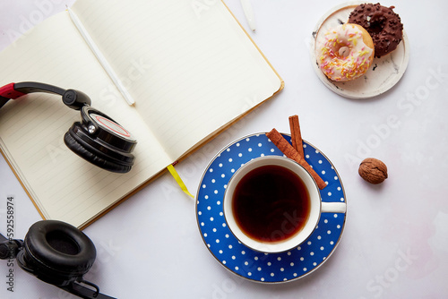 Mock up notepad with headphones, coffee cup with doughnuts. Online work, freelance, taking webinar, listen to music or audiobook, new normal. Cozy home
