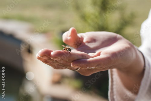 Woman holding bee on her finger tip