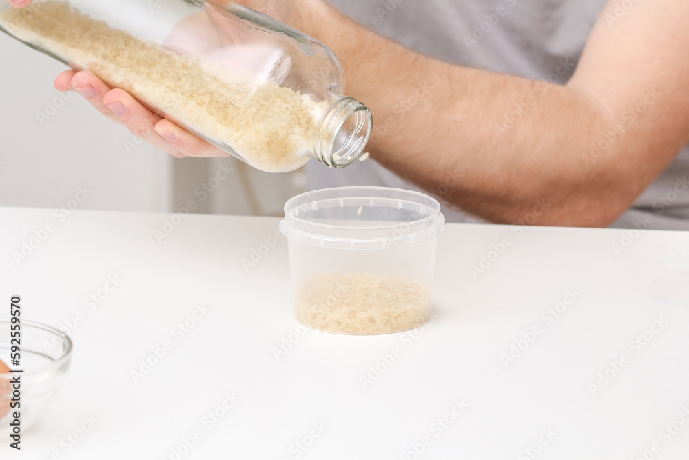 A man pours rice into a container. An unusual way of coloring and decorating Easter eggs. A man pours rice into a container. An unusual way of coloring and decorating Easter eggs.