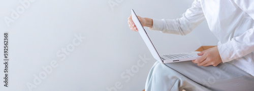 Woman sitting on the floor of the room and looking at computer.  部屋の床に座ってパソコンを見ている女性