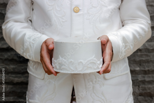 A man is holding a traditional white cloth cap (peci) with his hand photo
