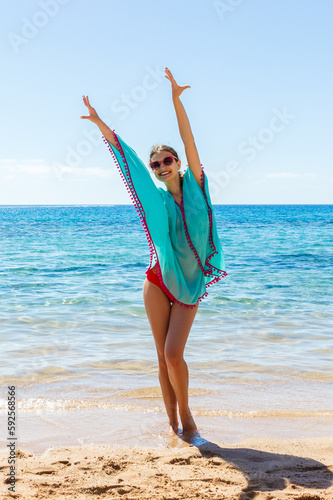 young beautiful blonde girl in glasses having fun on the beach