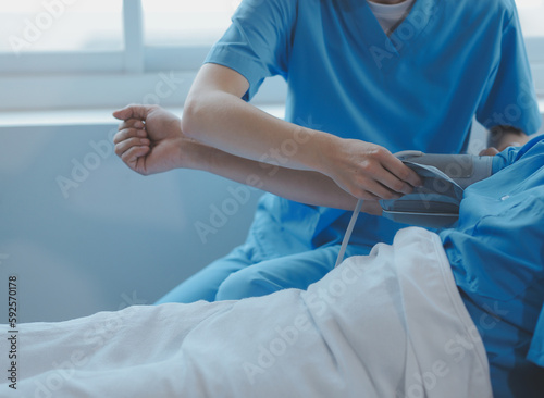 Injured patient showing doctor broken wrist and arm with bandage in hospital office or emergency room. Sprain, stress fracture or repetitive strain injury in hand. Nurse helping customer. First aid.