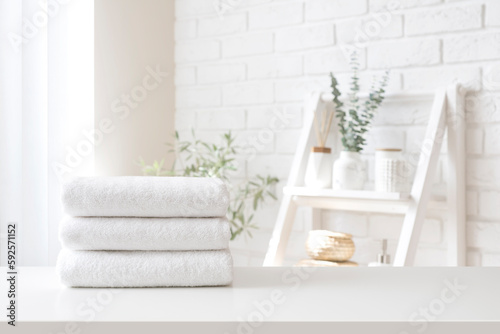 Spa towel stack on white table on bathroom interior background photo