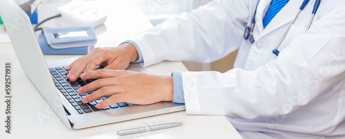 Close up man doctor hand typing on key board laptop computer  gadget on desk with copy space. Healthcare and medical worker people sickness hospital concept panoramic banner