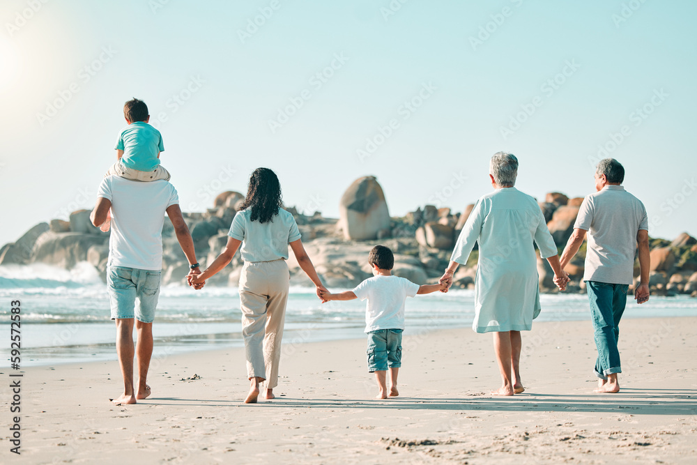 Holding hands, beach and rear view of big family walking at the sea, fun and travel on blue sky background. Behind, love and children with parents and grandparents on an ocean walk traveling in Miami